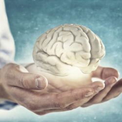 man holding a glowing human brain - deposit photos